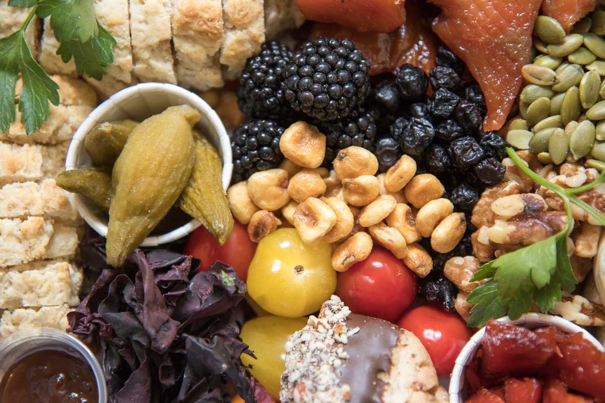 A mouthwatering closeup of charcuterie, including fresh bannock, dulce (sea bacon), cured meats, nuts and berries